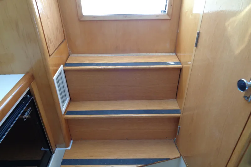 Slide: The Image of Wooden interior stairs on a 1994 Bertram 30 Moppie boat. - 45