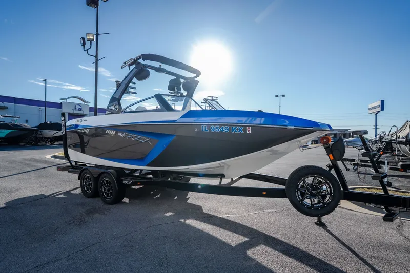 Slide: The Image of 2018 Tigé RZX3 boat on trailer, parked outdoors under bright sunlight. - 4