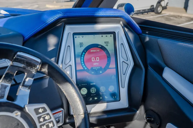 Slide: The Image of Dashboard of 2018 Tigé RZX3 boat with digital display and steering wheel. - 53