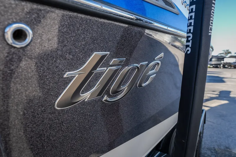 Slide: The Image of Close-up of 2018 Tigé RZX3 boat logo on a sleek, metallic surface. - 33