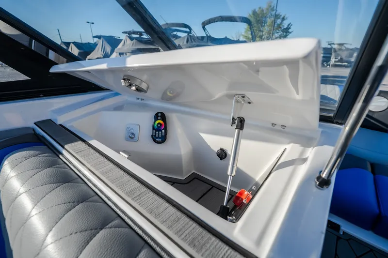 Slide: The Image of 2018 Tigé RZX3 boat interior storage compartment with control panel and cushioned seating. - 25