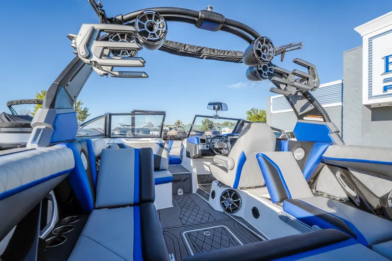 Slide: The Image of 2018 Tigé RZX3 boat interior with blue and gray seating, advanced sound system, and sleek design. - 6