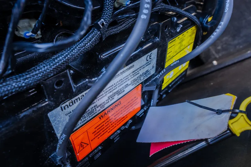 Slide: The Image of Close-up of 2018 Tigé RZX3 engine compartment with warning labels and cables. - 46