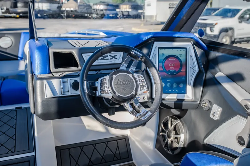 Slide: The Image of 2018 Tigé RZX3 boat dashboard with touchscreen display and steering wheel. - 50