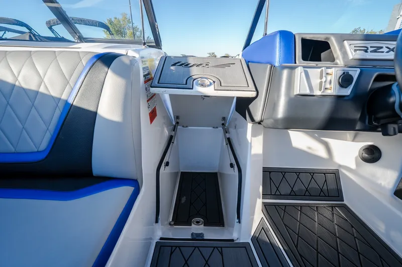 Slide: The Image of 2018 Tigé RZX3 boat interior with blue accents and diamond-stitched seating. - 29
