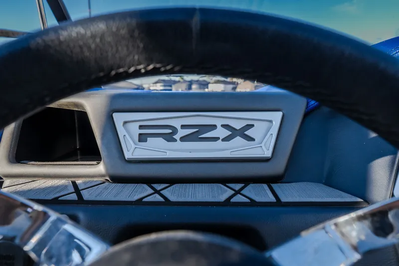 Slide: The Image of Steering wheel view of 2018 Tigé RZX3 boat dashboard with RZX emblem. - 52
