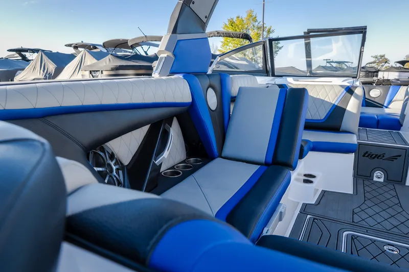 Slide: The Image of Interior of a 2018 Tigé RZX3 boat with blue and white seating. - 8