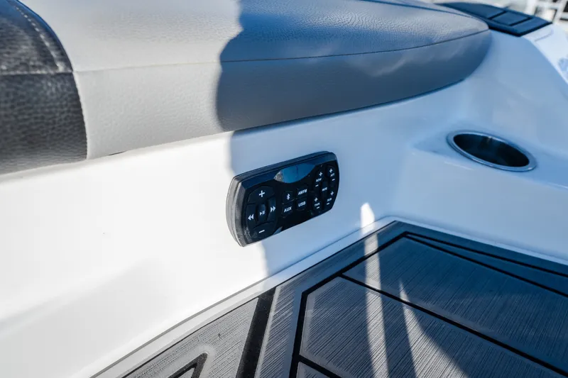 Slide: The Image of Control panel on 2018 Tigé RZX3 boat interior, featuring cushioned seating and cup holder. - 39