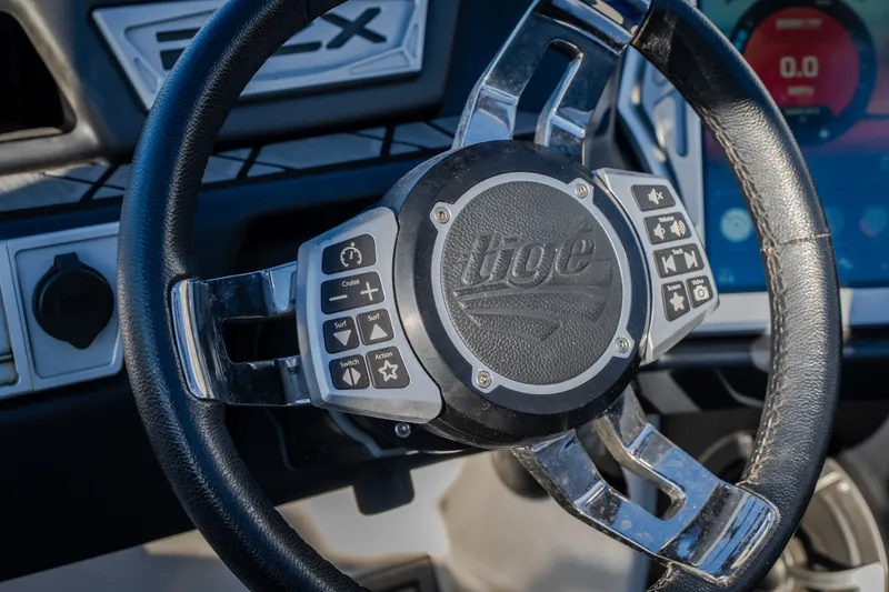 Slide: The Image of Steering wheel of 2018 Tigé RZX3 boat with control buttons and logo. - 51