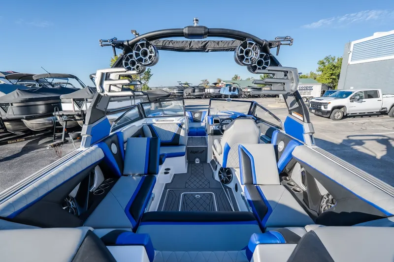 Slide: The Image of 2018 Tigé RZX3 boat interior with blue and gray seating, advanced sound system, and sleek design. - 5