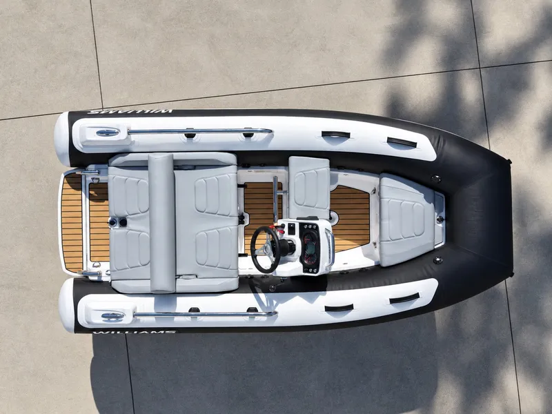 Slide: The Image of Williams Jet Tenders Sportjet 345 from 2026 with gray seats and wood decks, on a concrete floor. - 8