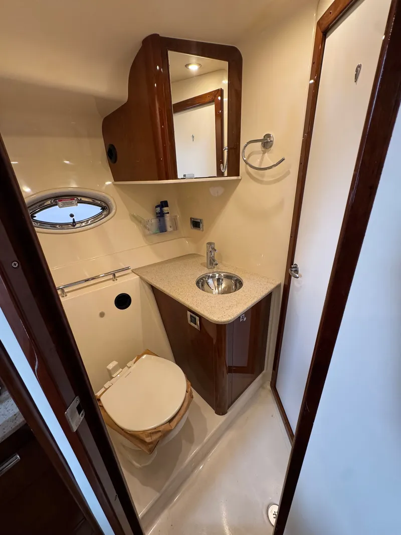 Slide: The Image of The image shows a sleek boat bathroom with a sink, toilet, and mirror. - 33