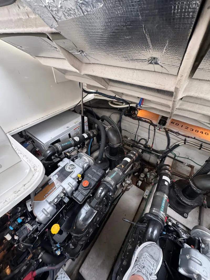 Slide: The Image of Engine room of the 2010 Sea Ray 390 Sundancer with complex piping and machinery. - 37