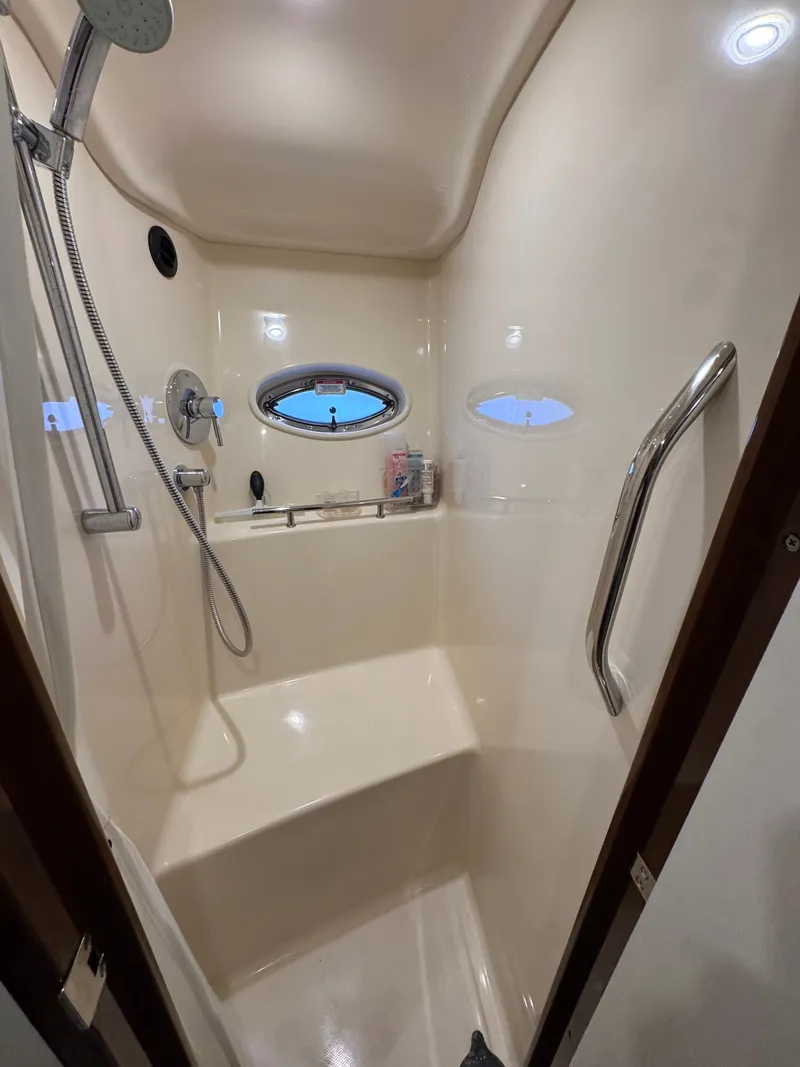 Slide: The Image of The shower cabin of a 2010 Sea Ray 390 Sundancer with a handheld showerhead and porthole window. - 34