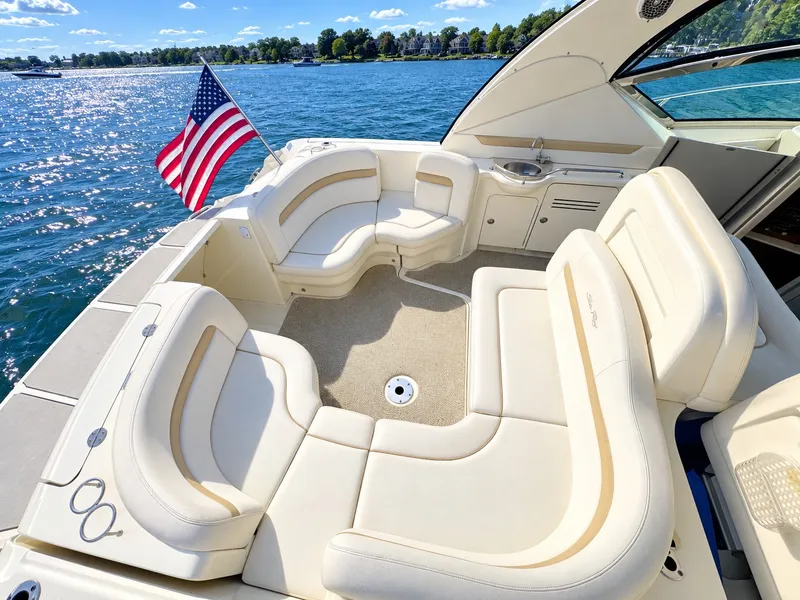 Slide: The Image of The image shows the cockpit of a 2010 Sea Ray 390 Sundancer with beige seating and an American flag. - 10
