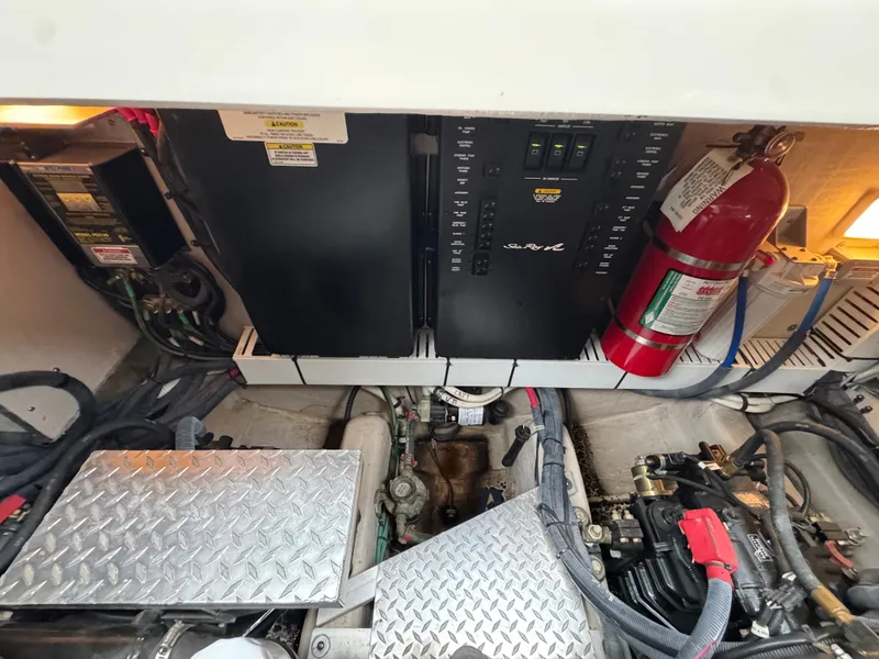 Slide: The Image of The engine room of a 2010 Sea Ray 390 Sundancer shows batteries, wiring, and a fire extinguisher. - 40