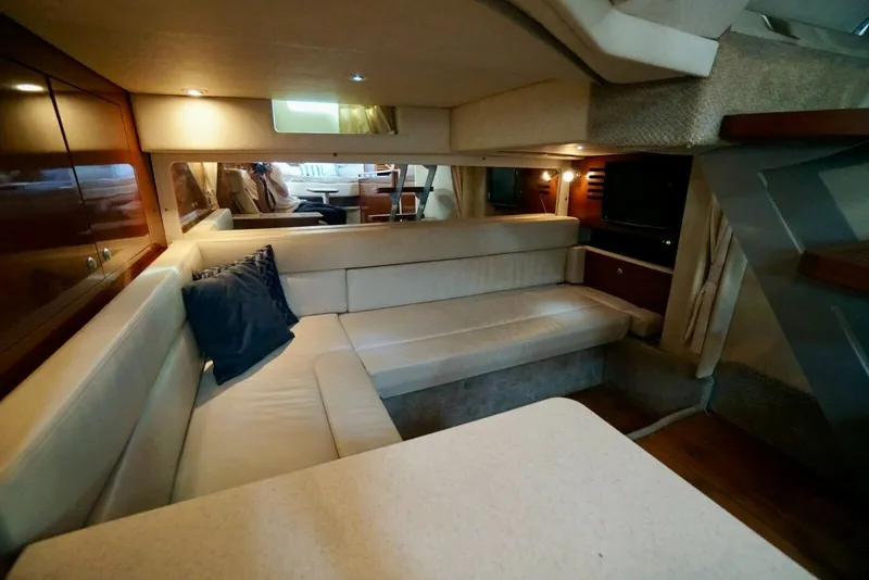 Slide: The Image of Interior of the 2010 Sea Ray 390 Sundancer with beige sofa and wooden cabinetry. - 30