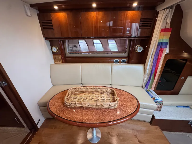 Slide: The Image of Interior of the Sea Ray 390 Sundancer with leather sofa and wooden table. - 28