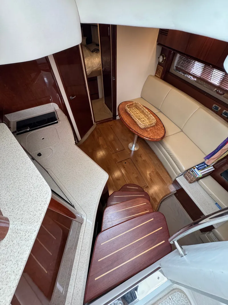 Slide: The Image of Interior of the 2010 Sea Ray 390 Sundancer with elegant seating area and wooden flooring. - 24