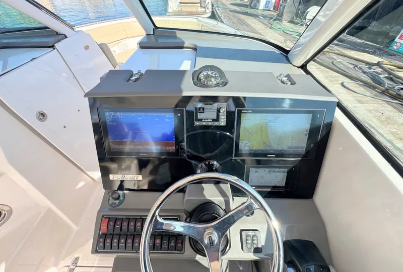Slide: The Image of The cockpit of the 2018 Pursuit DC 325 Dual Console features modern navigation systems and controls. - 14