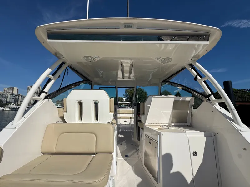 Slide: The Image of 2018 Pursuit DC 325 Dual Console with beige seating area and open cabin. - 16