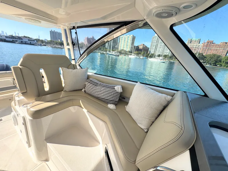 Slide: The Image of Interior of a 2018 Pursuit DC 325 Dual Console with beige seating and cushions. - 13