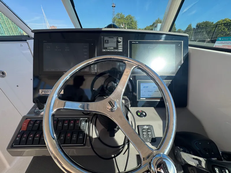 Slide: The Image of The image shows the helm of a 2018 Pursuit DC 325 Dual Console boat. - 15
