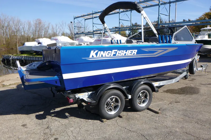 Slide: The Image of Blue 2027 KingFisher 2025 Escape boat on trailer, parked outdoors. - 2