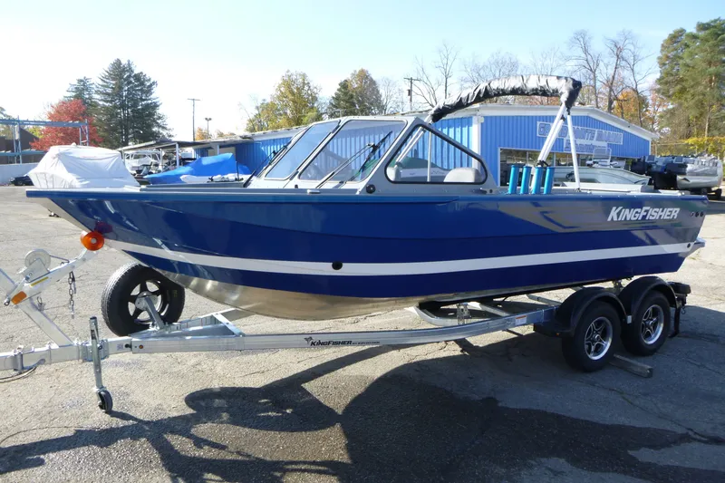 Slide: The Image of Blue 2027 KingFisher 2025 Escape boat on trailer, parked outdoors. - 5
