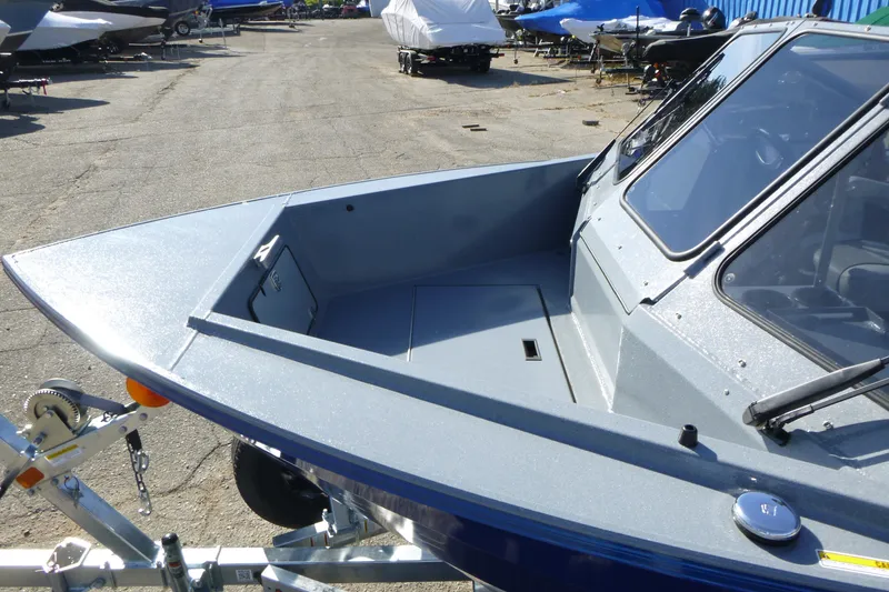Slide: The Image of KingFisher 2025 Escape boat, 2027 model, parked on a trailer in a marina. - 8
