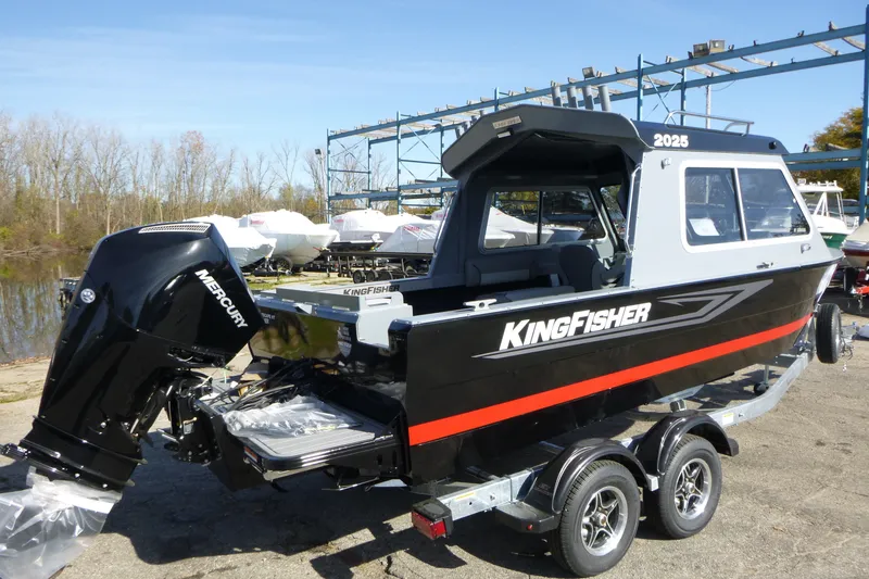 Slide: The Image of KingFisher 2025 Escape HT boat with Mercury engine, parked on a trailer, 2027 model. - 2