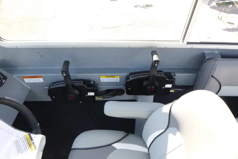 Slide: The Image of Interior controls of a 2027 KingFisher 2025 Escape HT boat, featuring dual throttle levers. - 19