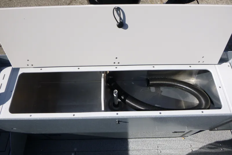 Slide: The Image of Open storage compartment in KingFisher 2025 Escape HT boat, featuring hoses, 2027 model. - 27