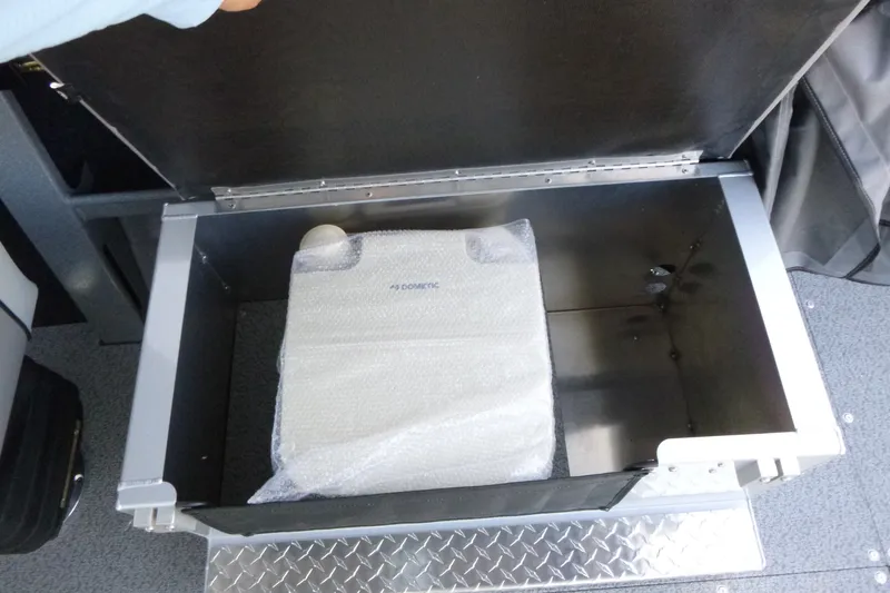 Slide: The Image of Storage compartment in KingFisher 2025 Escape HT boat, featuring a wrapped Dometic item. - 22