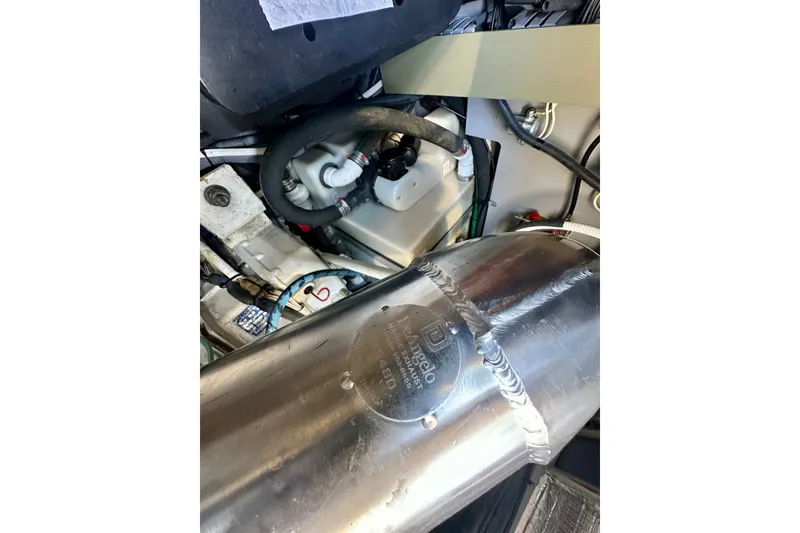 Slide: The Image of Engine compartment of a 2001 Sea Ray Sundancer 460 boat, featuring metal components and hoses. - 39