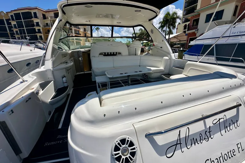 Slide: The Image of 2001 Sea Ray Sundancer 460 yacht with spacious seating, docked in a marina under a clear sky. - 9
