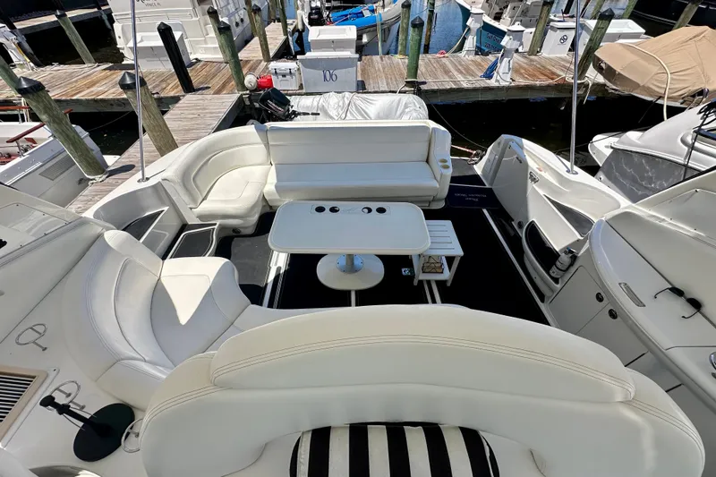 Slide: The Image of Luxurious 2001 Sea Ray Sundancer 460 yacht interior with white seating and table at marina. - 14