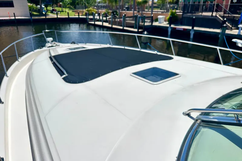 Slide: The Image of 2001 Sea Ray Sundancer 460 yacht deck with sunpad and hatch, docked in a marina. - 30