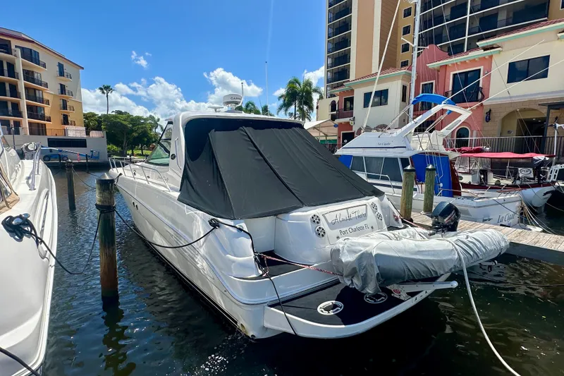 Slide: The Image of 2001 Sea Ray Sundancer 460 docked at marina, surrounded by buildings and boats. - 4