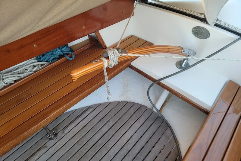 Slide: The Image of Wooden interior of 2006 Ensign 23 sailboat with ropes and tiller. - 26