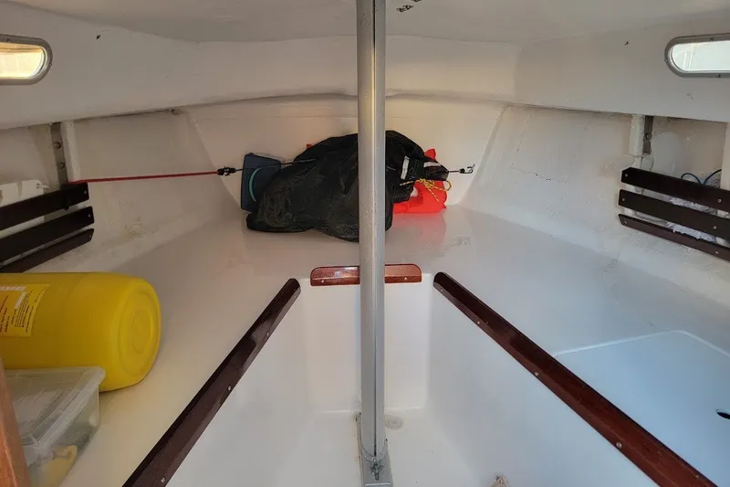 Slide: The Image of Interior of 2006 Ensign 23 sailboat, showing cabin space and storage items. - 21