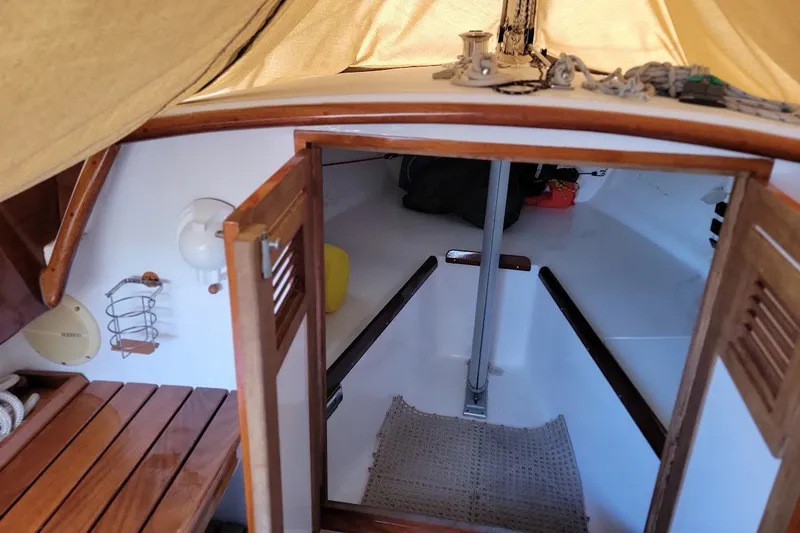 Slide: The Image of Interior view of 2006 Ensign 23 sailboat cabin with wooden accents and nautical equipment. - 20