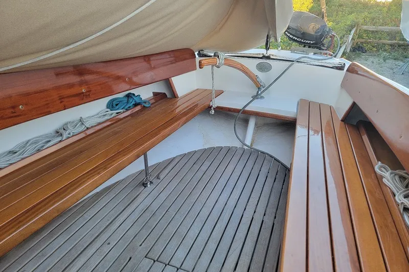 Slide: The Image of Wooden interior of 2006 Ensign 23 sailboat with ropes and outboard motor. - 29