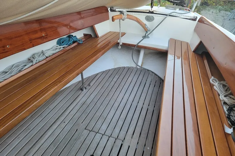 Slide: The Image of Interior of 2006 Ensign 23 sailboat with polished wooden benches and coiled ropes. - 17