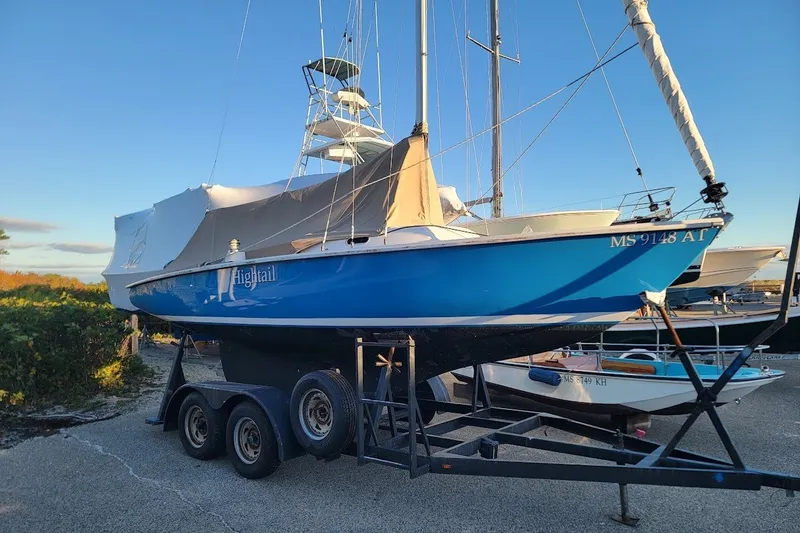 Slide: The Image of Blue 2006 Ensign 23 sailboat on trailer, named "Hightail," parked outdoors. - 13