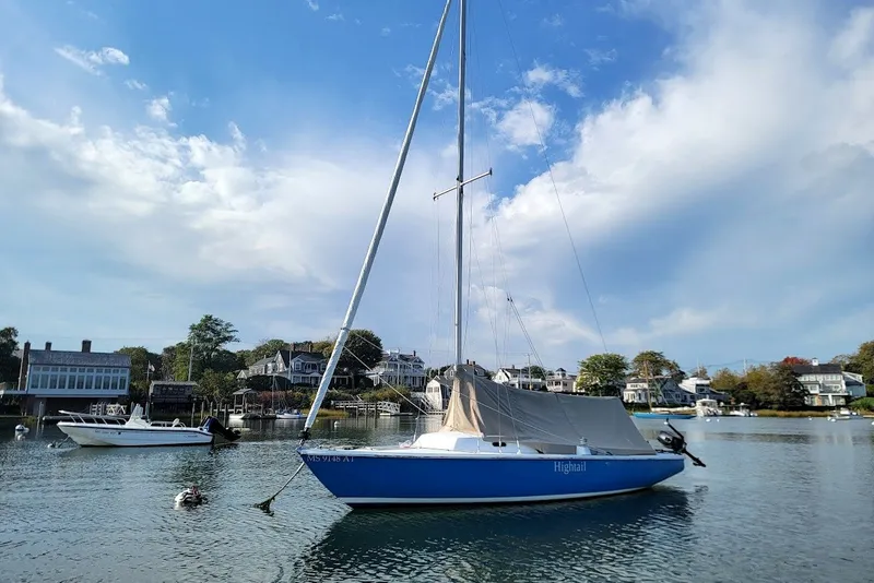 The Image of Sailboat "Hightail" on calm water, Ensign 23 model, 2006, with scenic coastal backdrop. - 14