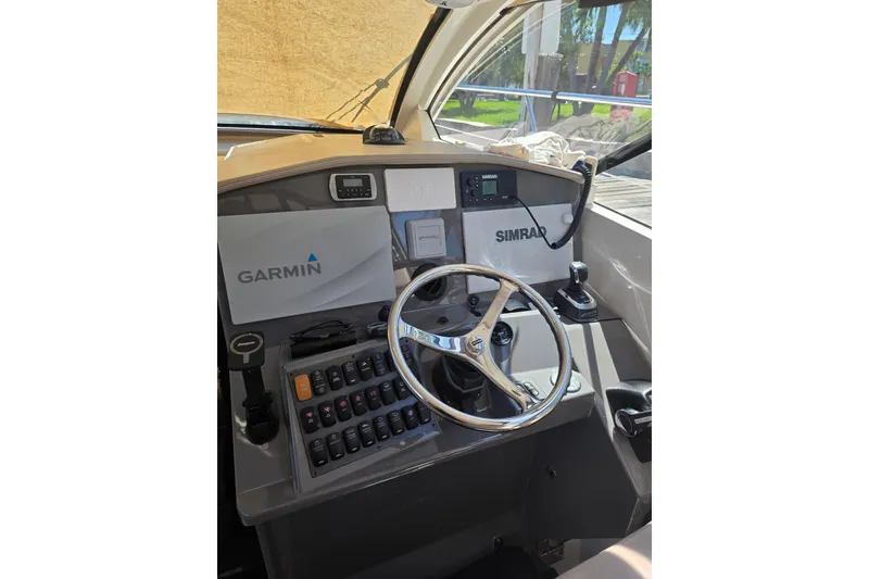 Slide: The Image of Cockpit of 2015 Pursuit SC 365i Sport Coupe with Garmin and Simrad navigation systems. - 13