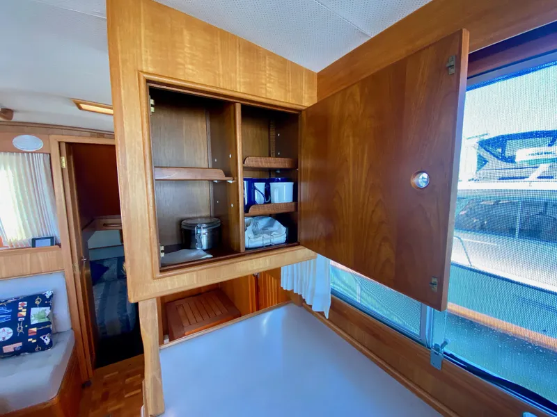 Slide: The Image of Interior of 1997 Grand Banks Classic yacht with open wooden cabinet and visible storage items. - 25