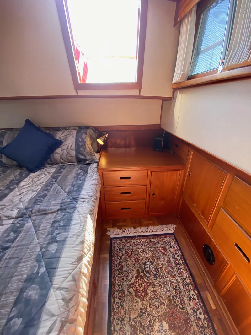 Slide: The Image of Cozy cabin interior of 1997 Grand Banks Classic yacht with bed, wooden cabinetry, and rug. - 28