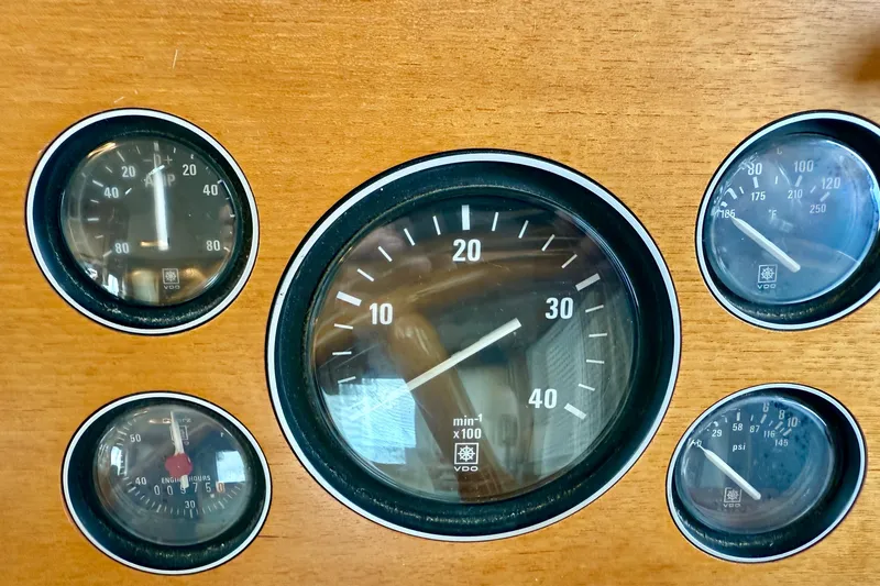 Slide: The Image of 1997 Grand Banks Classic dashboard with five analog gauges on wooden panel. - 48